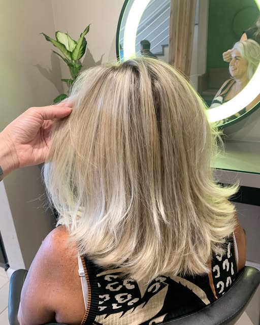 Cabelo loiro com mechas, em corte médio repicado